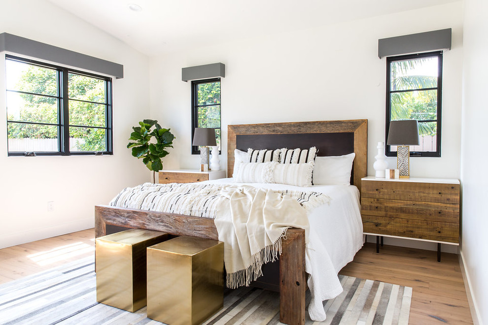 Großes Country Hauptschlafzimmer ohne Kamin mit weißer Wandfarbe, hellem Holzboden und beigem Boden in Los Angeles