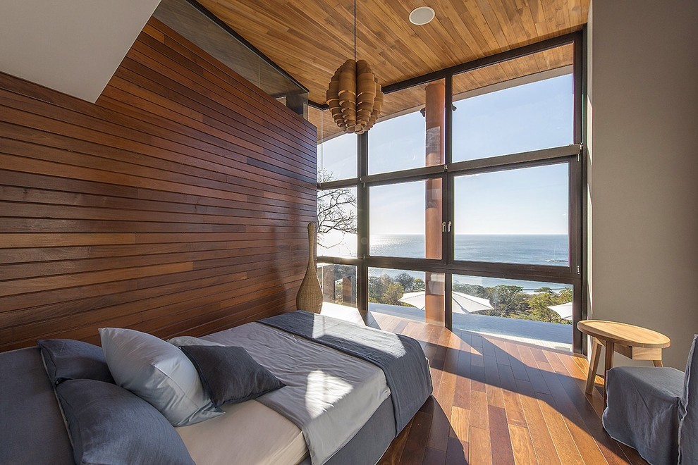 Kleines Modernes Gästezimmer ohne Kamin mit braunem Holzboden und beiger Wandfarbe in New York