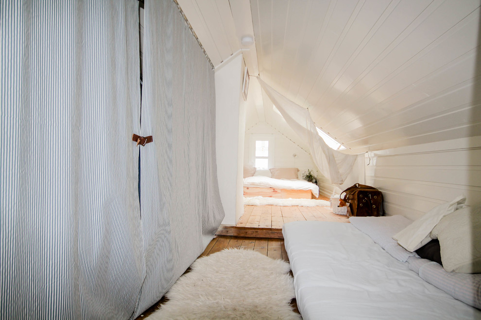 Inspiration för små minimalistiska sovloft, med vita väggar och mellanmörkt trägolv