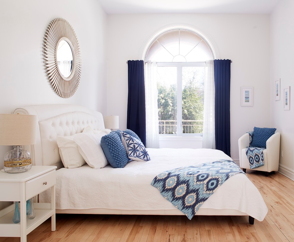Exemple d'une chambre parentale tendance de taille moyenne avec un mur blanc et parquet clair.