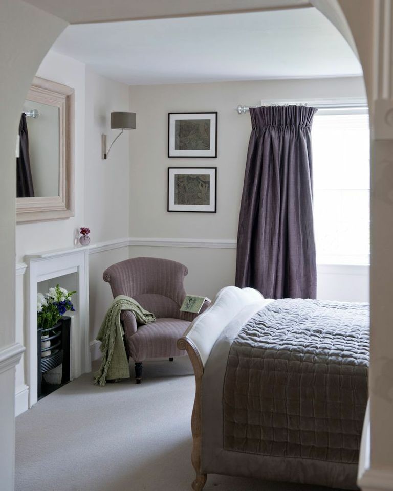 Inspiration for a mid-sized farmhouse carpeted bedroom remodel in London with beige walls, no fireplace and a wood fireplace surround