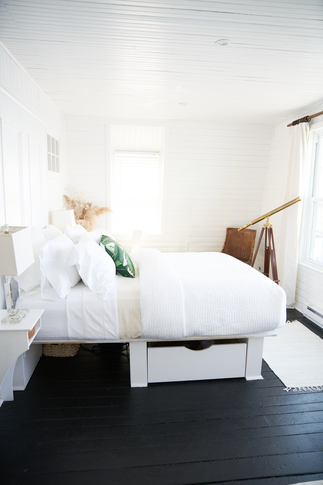 На фото: маленькая хозяйская спальня в морском стиле с белыми стенами, деревянным полом и черным полом без камина для на участке и в саду