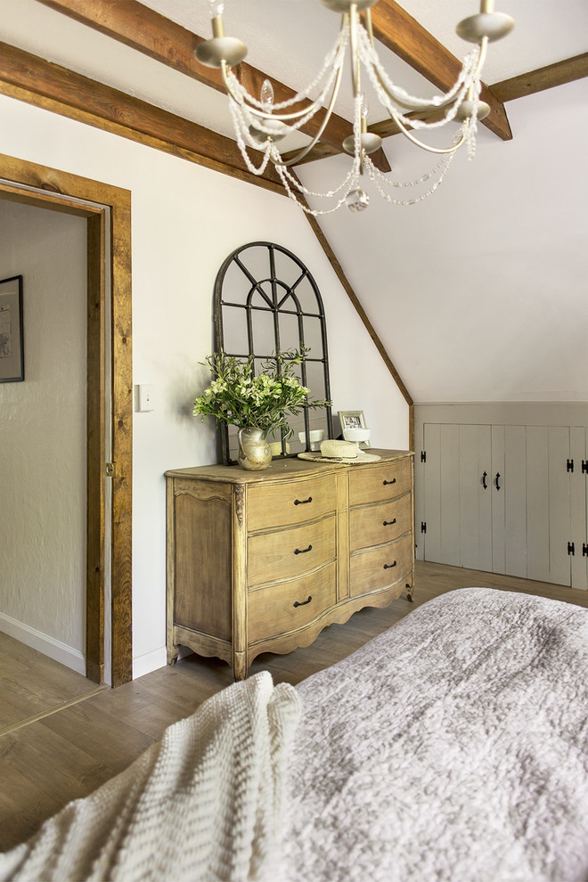 Bedroom - mid-sized rustic master laminate floor and brown floor bedroom idea in Tampa with white walls