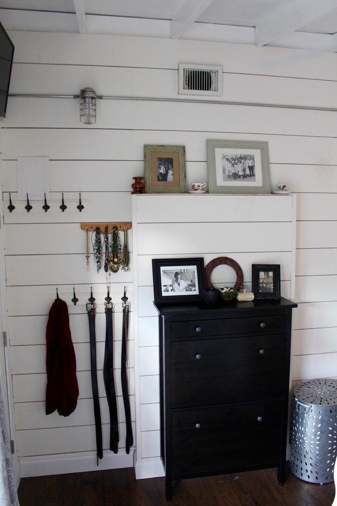 Cette image montre une petite chambre parentale rustique avec un mur blanc.