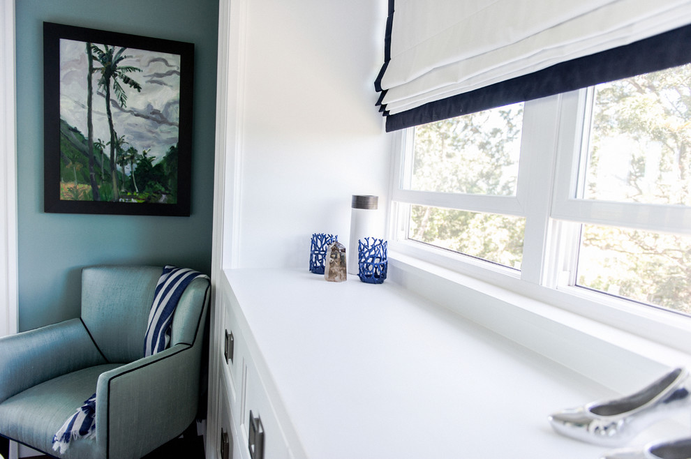 Cette image montre une petite chambre d'amis marine avec un mur bleu et parquet foncé.