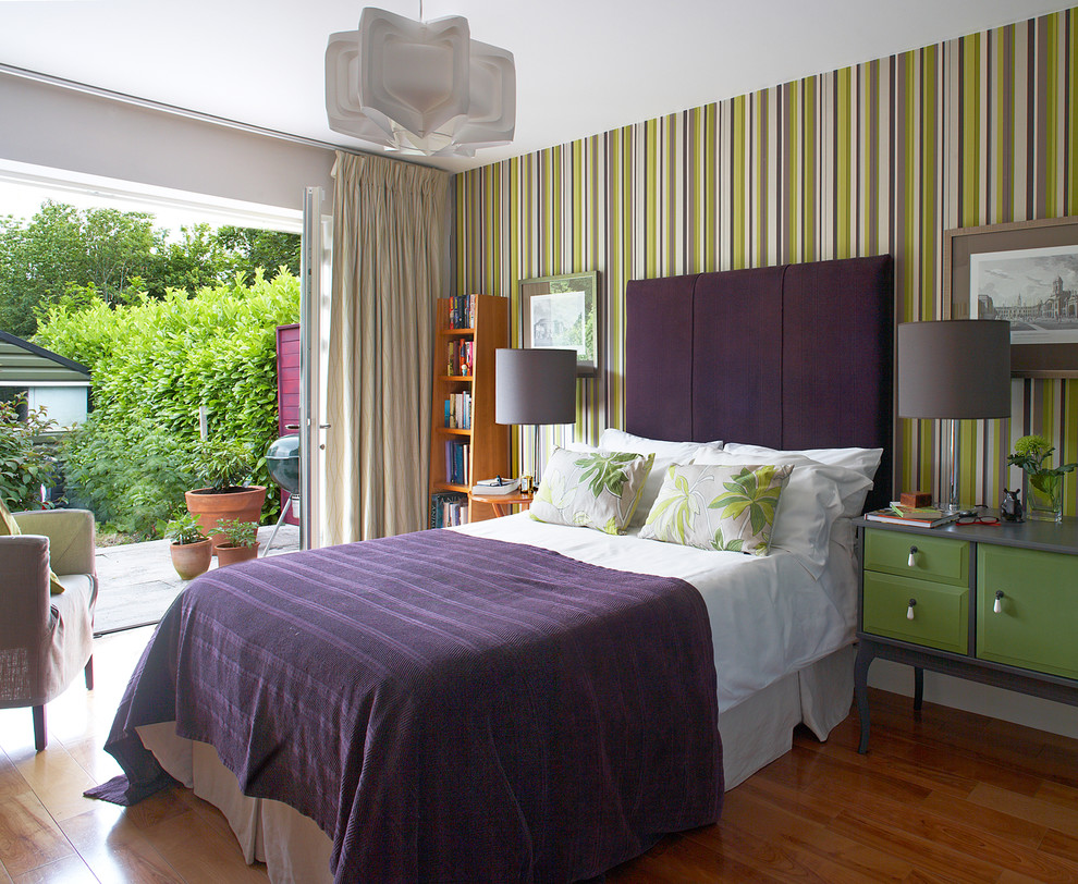 Idee per una camera da letto design con pareti multicolore e pavimento in legno massello medio