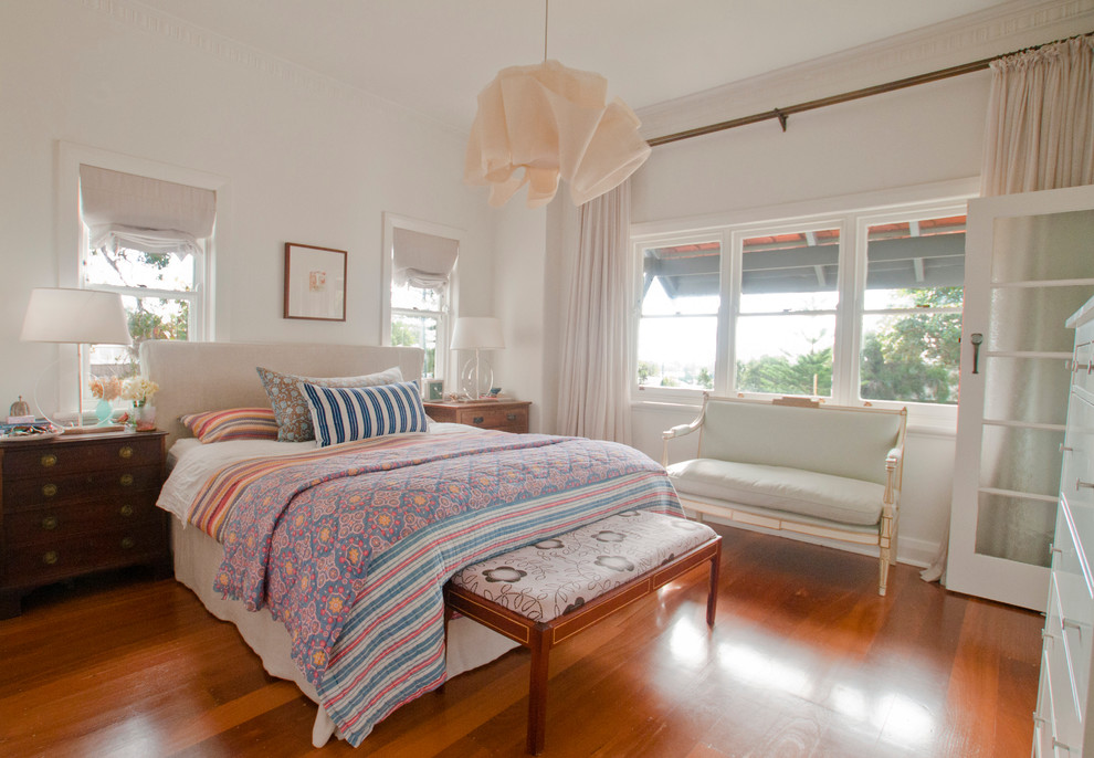 Esempio di una camera da letto boho chic di medie dimensioni con pareti bianche e pavimento in legno massello medio