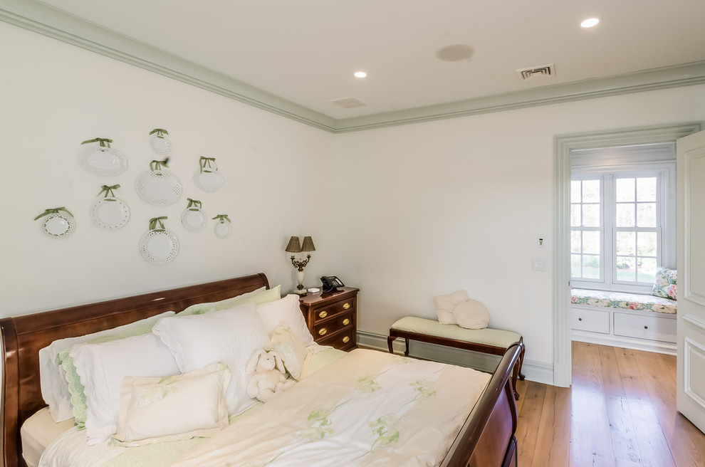 Esempio di una camera degli ospiti tradizionale di medie dimensioni con pareti bianche e pavimento in legno massello medio