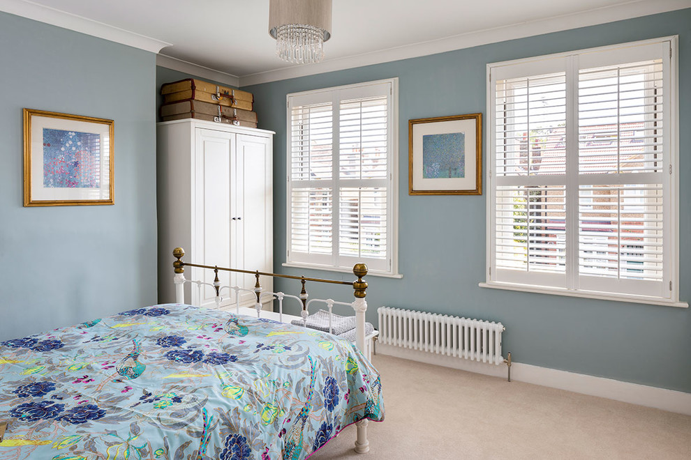 Modelo de dormitorio principal moderno pequeño con paredes azules y moqueta