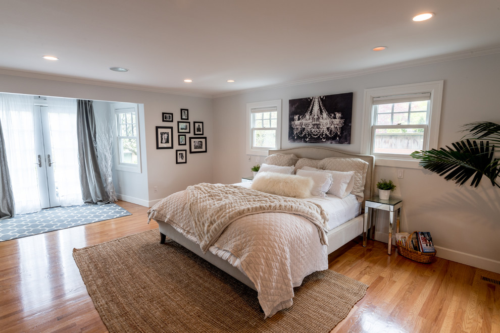 This is an example of an expansive classic master bedroom in Portland with white walls, light hardwood flooring, no fireplace and brown floors.
