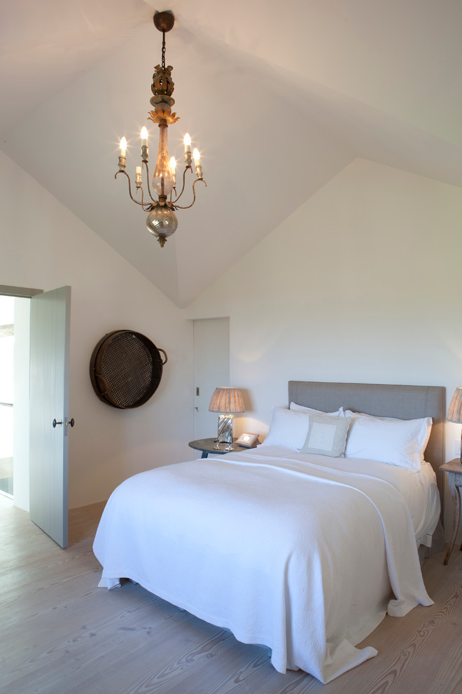 Foto de dormitorio de estilo de casa de campo con paredes blancas y suelo de madera clara