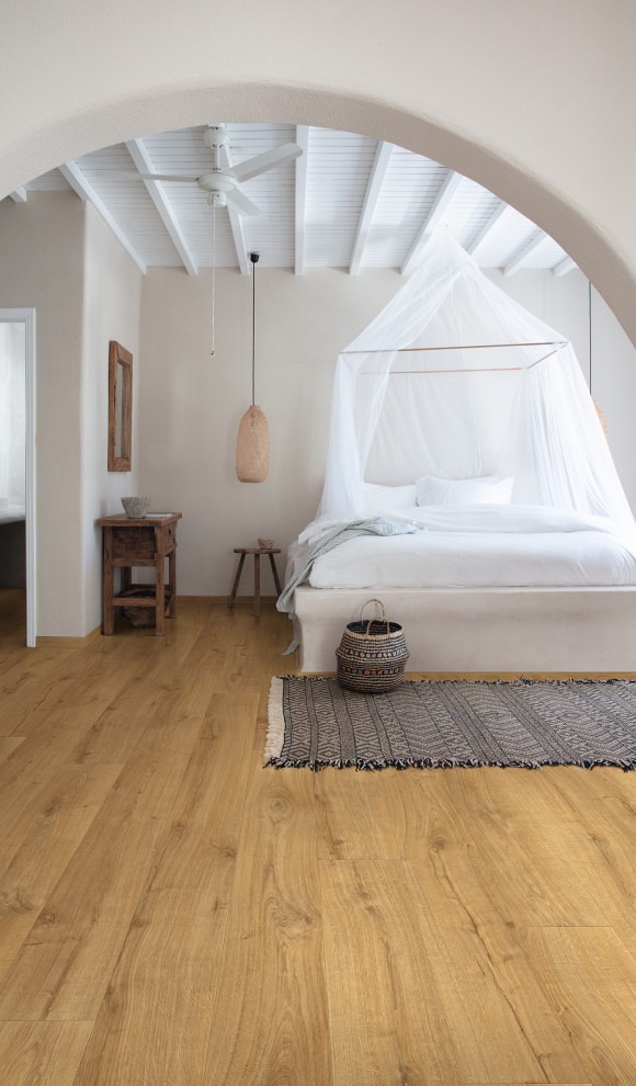 Ejemplo de dormitorio campestre con suelo laminado y suelo beige