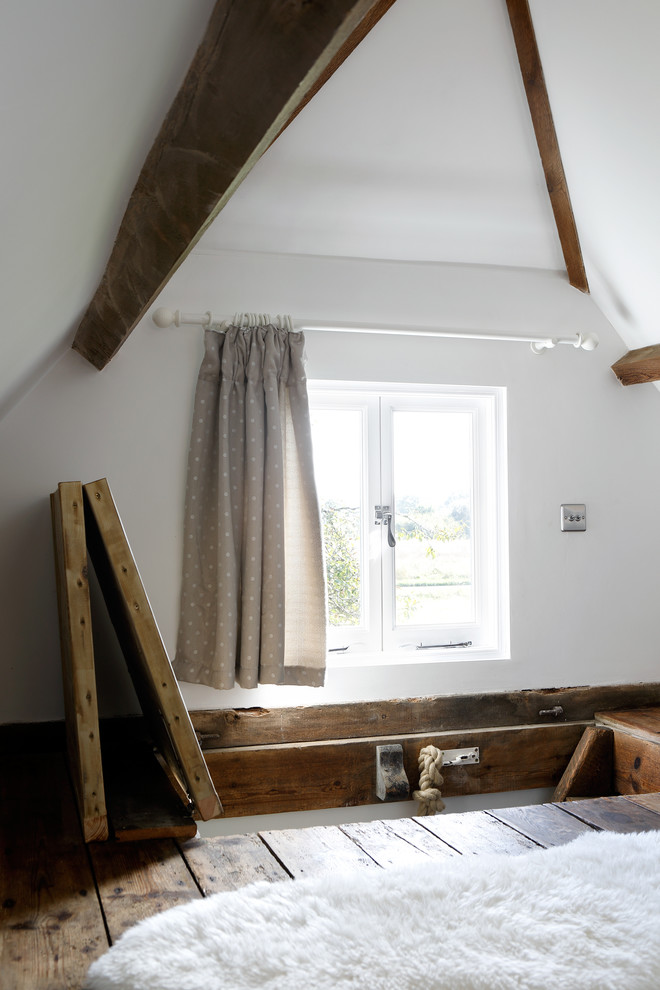 Ispirazione per una piccola camera da letto stile loft stile rurale con pareti bianche e parquet scuro