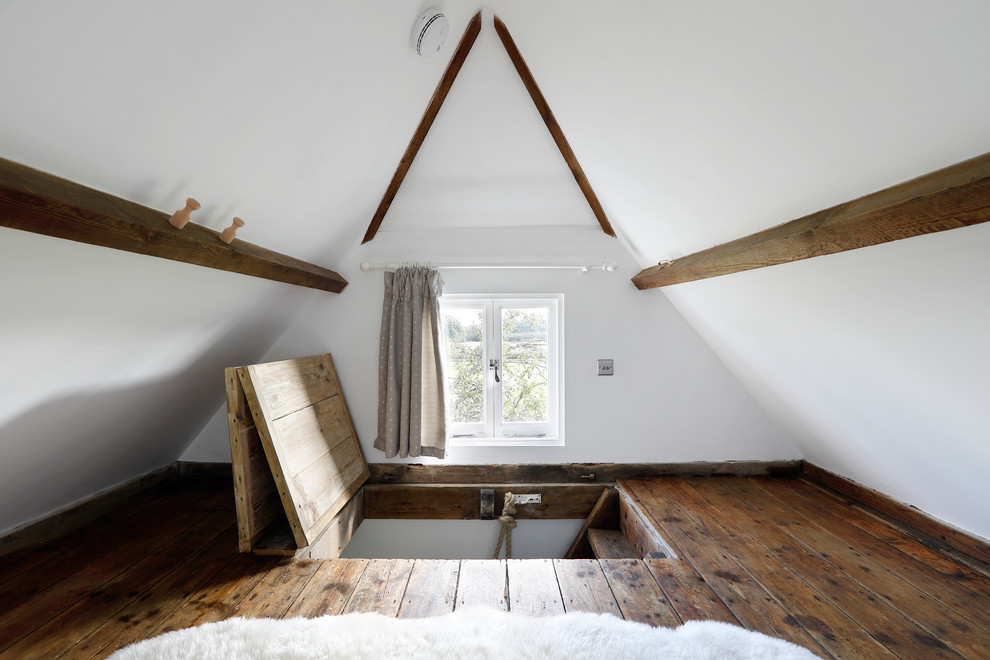 Ejemplo de dormitorio de estilo de casa de campo pequeño con paredes blancas, suelo de madera oscura y techo inclinado