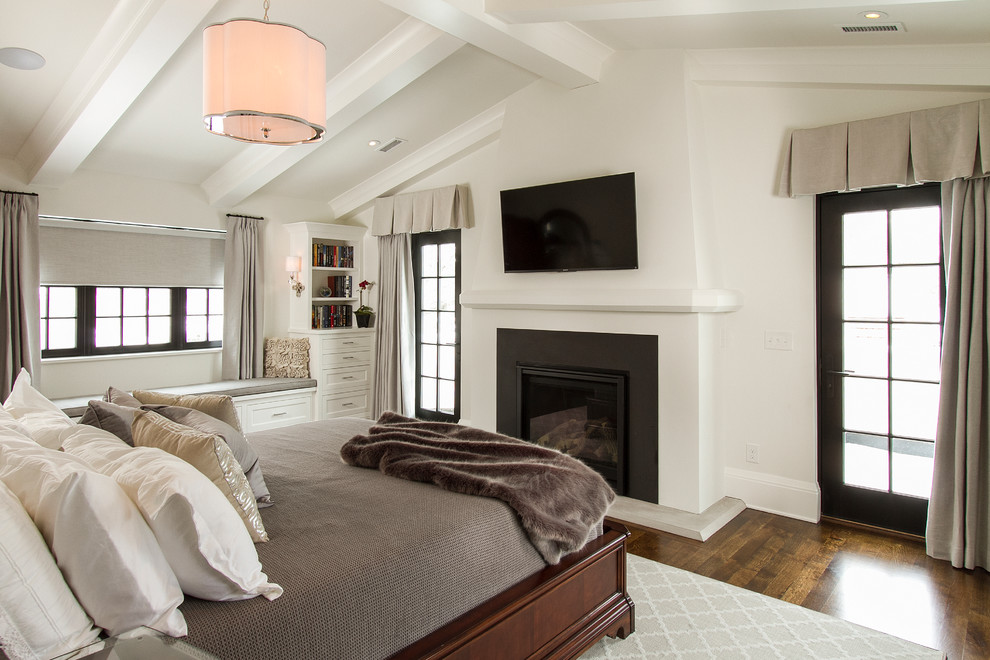 Foto de dormitorio principal clásico con paredes blancas, suelo de madera en tonos medios, todas las chimeneas y marco de chimenea de metal