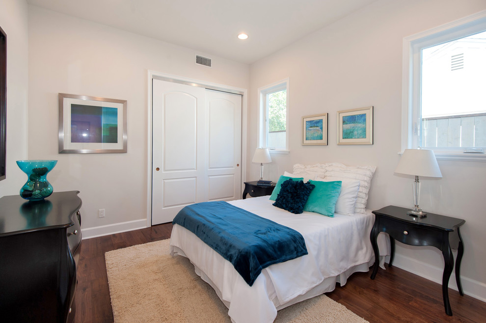 Imagen de habitación de invitados contemporánea de tamaño medio con paredes blancas y suelo de madera en tonos medios