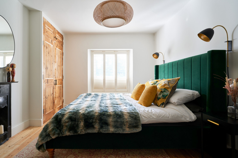 Example of a mid-sized trendy master medium tone wood floor and brown floor bedroom design in Oxfordshire with green walls