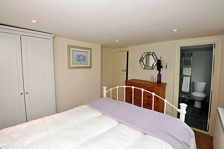 Imagen de dormitorio principal campestre pequeño con paredes beige y moqueta
