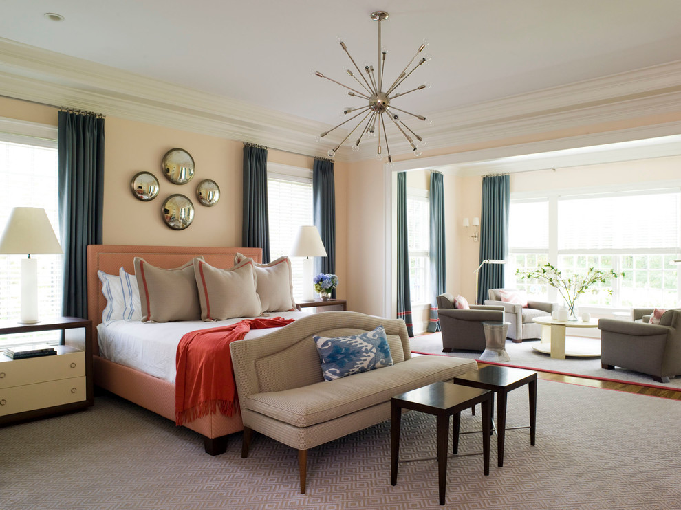 Foto di una camera da letto design con pareti arancioni e moquette