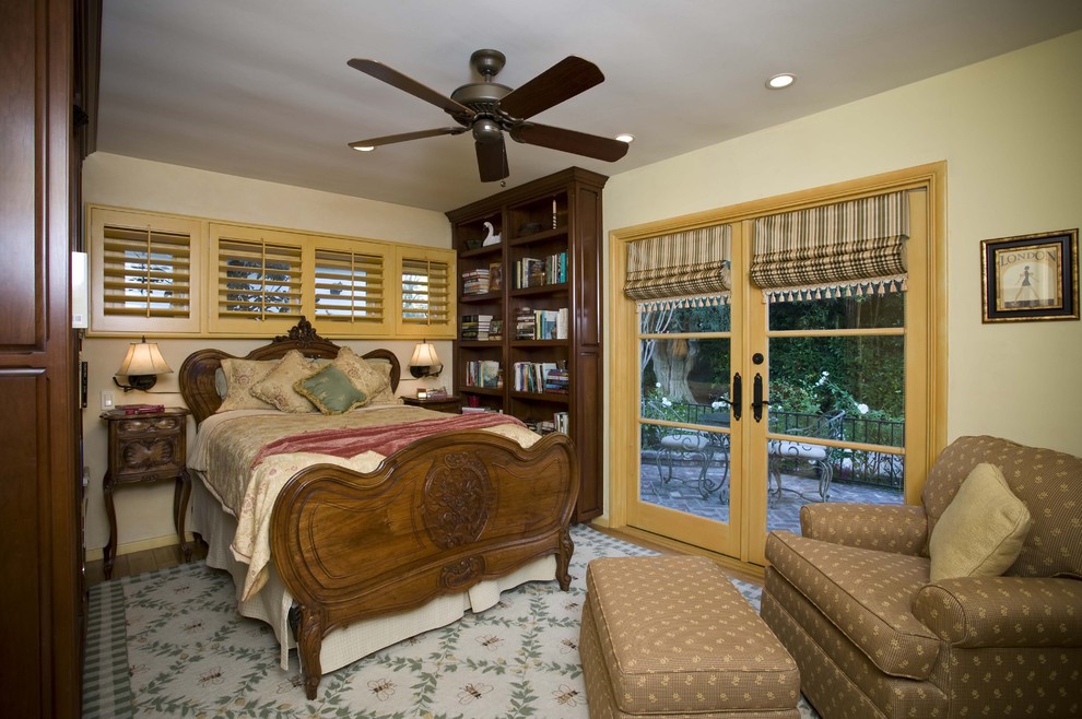 Idee per una camera degli ospiti di medie dimensioni con pareti gialle, pavimento in legno massello medio e pavimento marrone