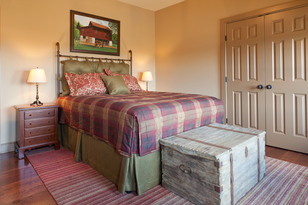 Ejemplo de habitación de invitados de estilo de casa de campo con paredes amarillas y suelo de madera en tonos medios