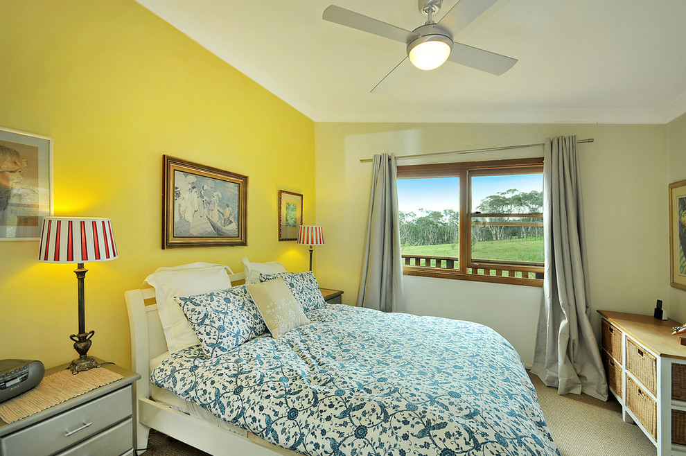 Kleines Landhausstil Schlafzimmer mit gelber Wandfarbe und Teppichboden in Sonstige