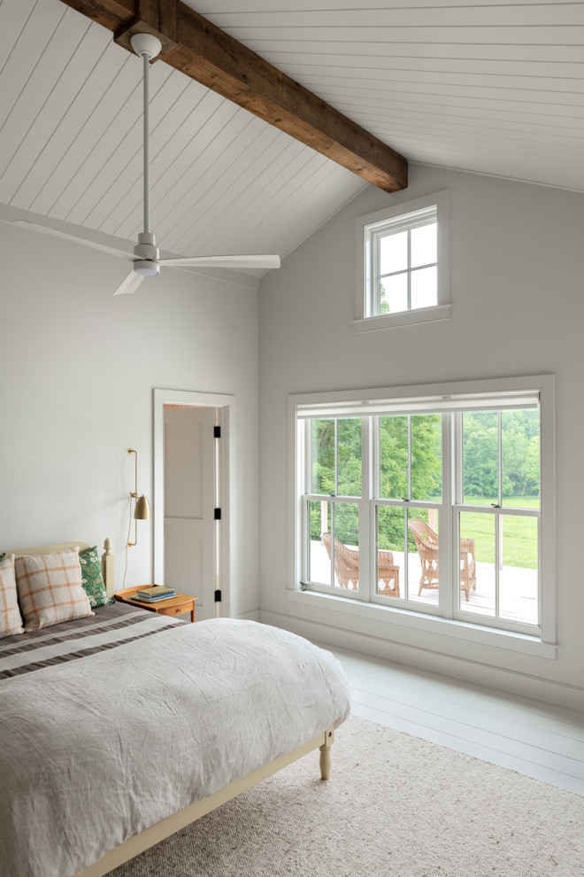 Modelo de dormitorio abovedado de estilo de casa de campo con paredes blancas, suelo de madera pintada y suelo blanco