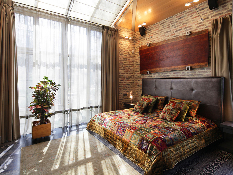 Immagine di una grande camera da letto stile loft contemporanea con pareti grigie e pavimento in legno verniciato