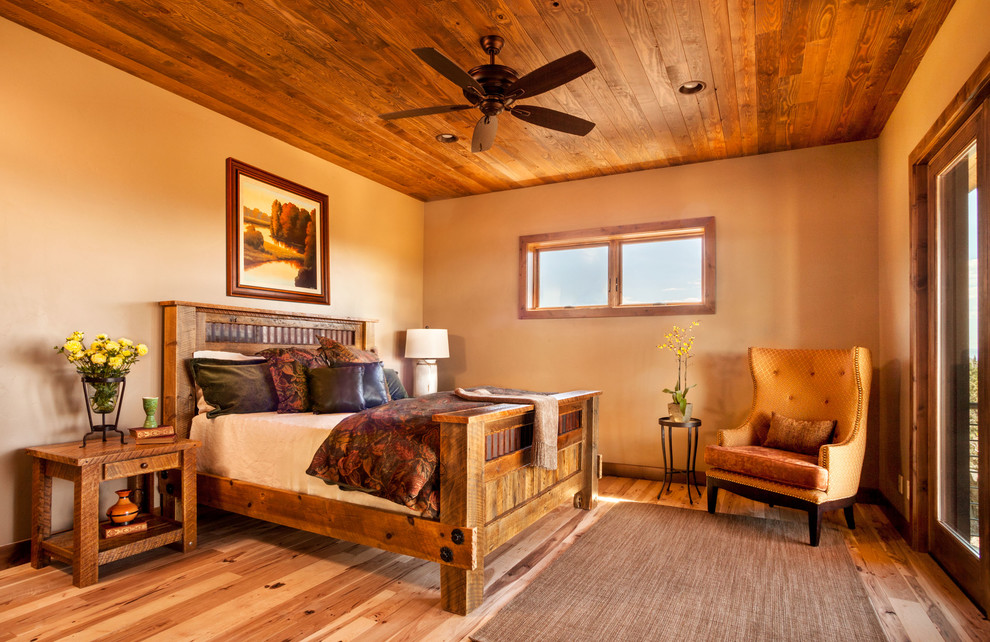 Imagen de habitación de invitados rural de tamaño medio sin chimenea con paredes beige, suelo de madera clara y suelo marrón
