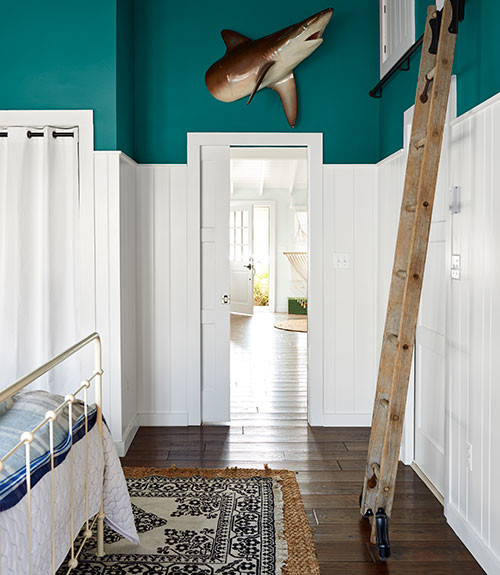 Immagine di una piccola camera da letto stile loft stile marino con pareti blu, parquet scuro e pavimento marrone