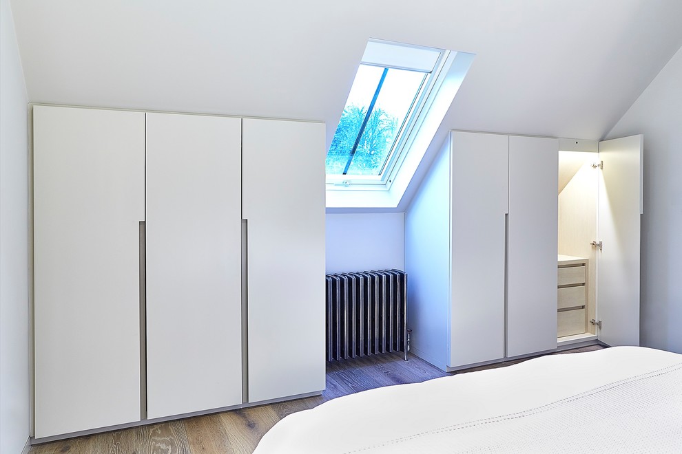 Diseño de habitación de invitados actual de tamaño medio con paredes beige y suelo de madera en tonos medios