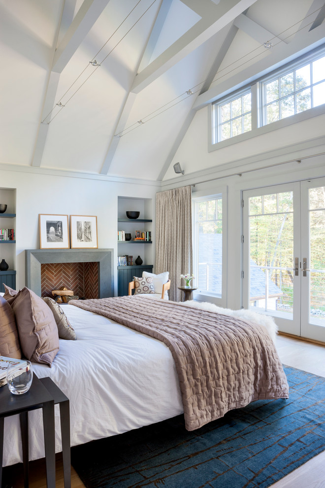 ボストンにあるビーチスタイルのおしゃれな寝室 (白い壁、淡色無垢フローリング、標準型暖炉)