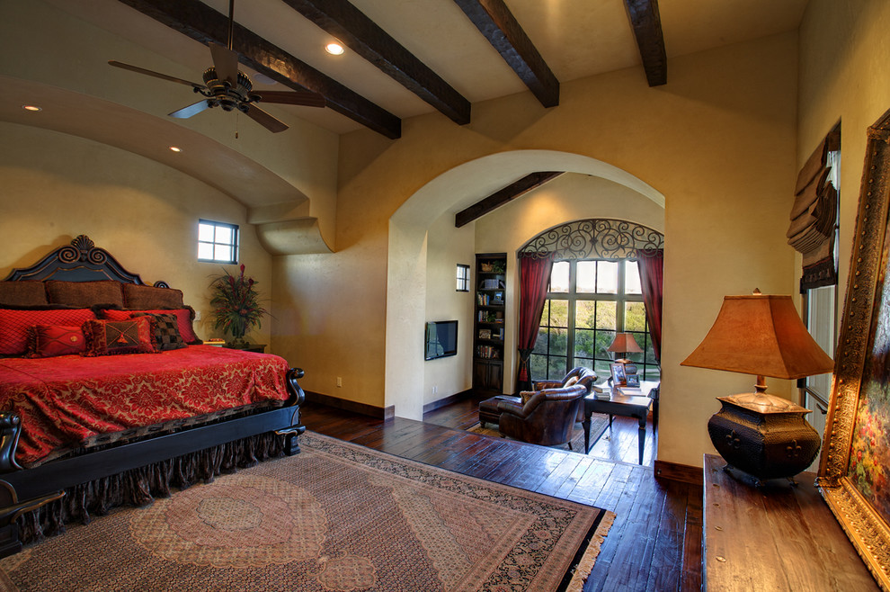 Mediterranes Schlafzimmer mit beiger Wandfarbe und dunklem Holzboden in Austin