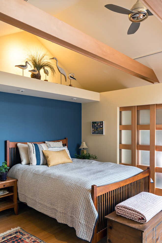 Diseño de habitación de invitados costera de tamaño medio con paredes beige y suelo de madera clara