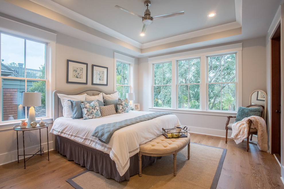 Foto de habitación de invitados tradicional renovada de tamaño medio sin chimenea con paredes grises, suelo de madera en tonos medios y suelo marrón