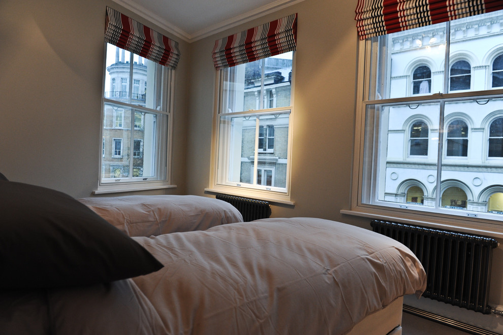 Imagen de habitación de invitados moderna de tamaño medio con paredes beige y moqueta
