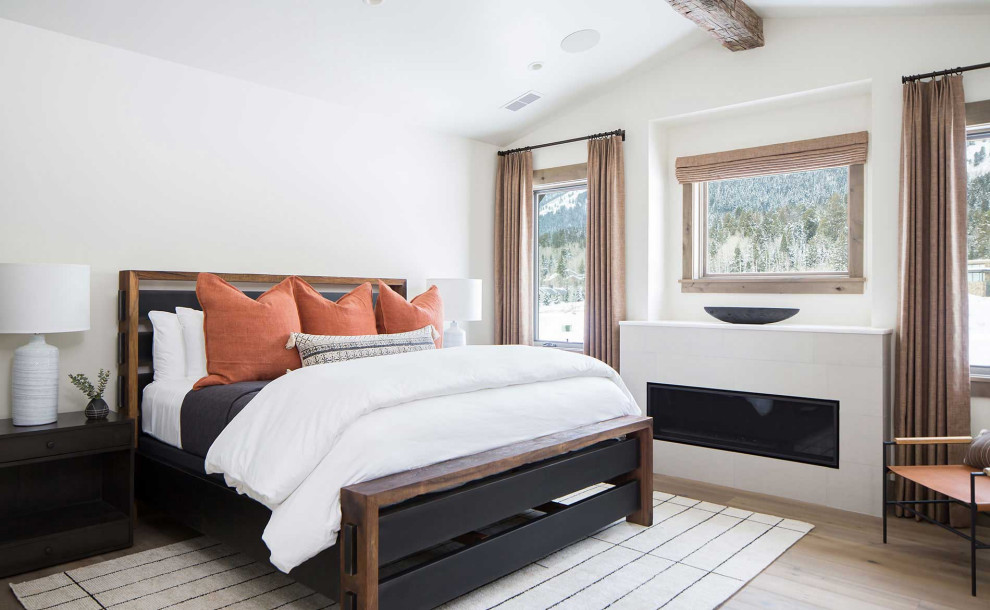 На фото: гостевая спальня (комната для гостей) в стиле рустика с светлым паркетным полом, горизонтальным камином и фасадом камина из плитки с