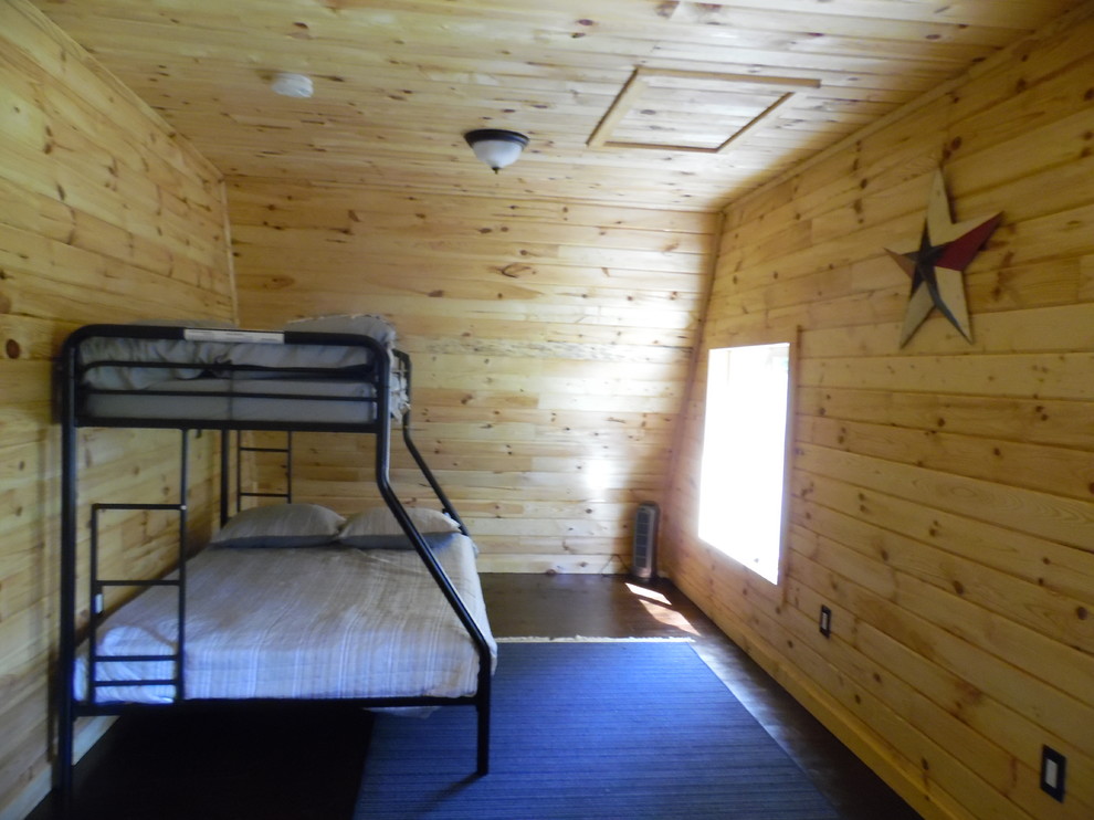 Cette photo montre une petite chambre mansardée ou avec mezzanine montagne avec un mur beige et parquet foncé.