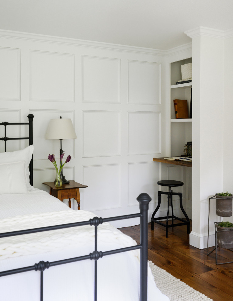 Ejemplo de habitación de invitados de estilo de casa de campo con suelo de madera en tonos medios y panelado