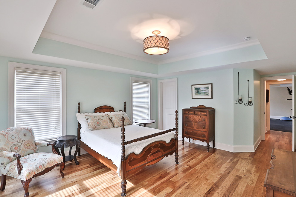 Inspiration pour une chambre d'amis traditionnelle de taille moyenne avec un mur bleu, un sol en bois brun et aucune cheminée.