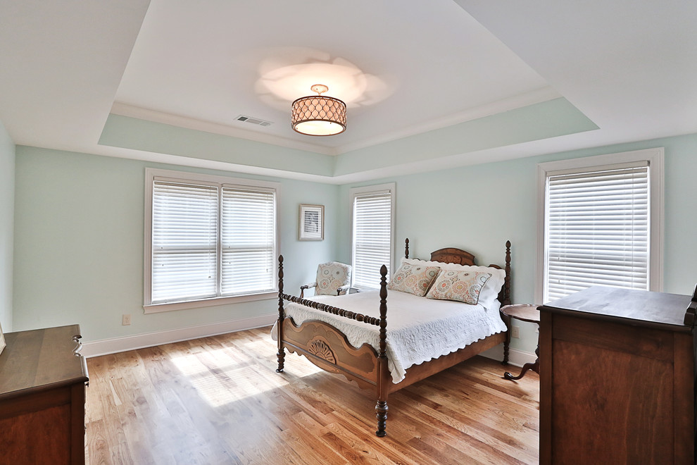 Immagine di una camera degli ospiti chic di medie dimensioni con pareti blu, pavimento in legno massello medio e nessun camino