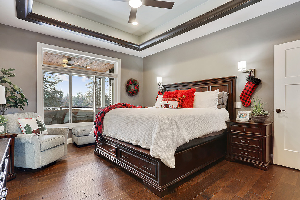 Foto de dormitorio clásico renovado con paredes grises, suelo de madera en tonos medios y suelo marrón