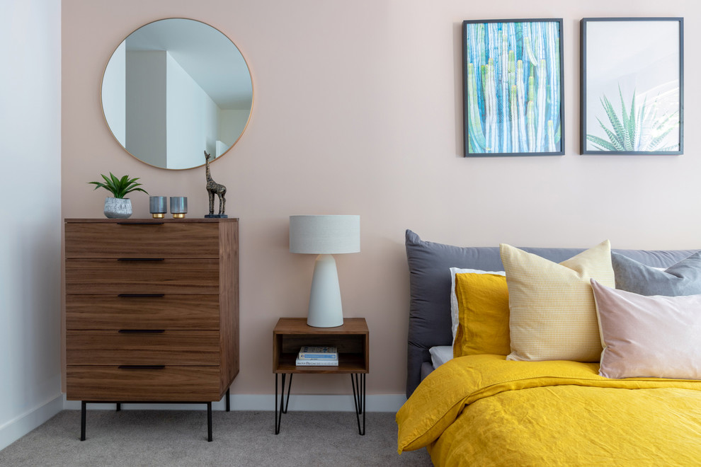 Modelo de dormitorio contemporáneo con paredes rosas, moqueta y suelo gris