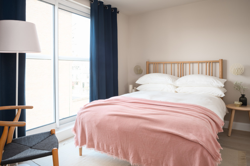 Photo of a scandinavian guest bedroom in London with beige walls, light hardwood flooring and beige floors.