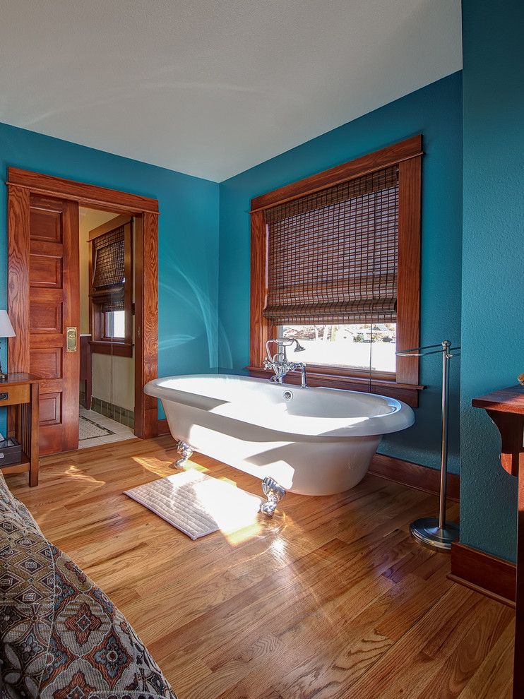 Стильный дизайн: хозяйская спальня среднего размера в стиле кантри с синими стенами, паркетным полом среднего тона, стандартным камином, фасадом камина из плитки и коричневым полом - последний тренд