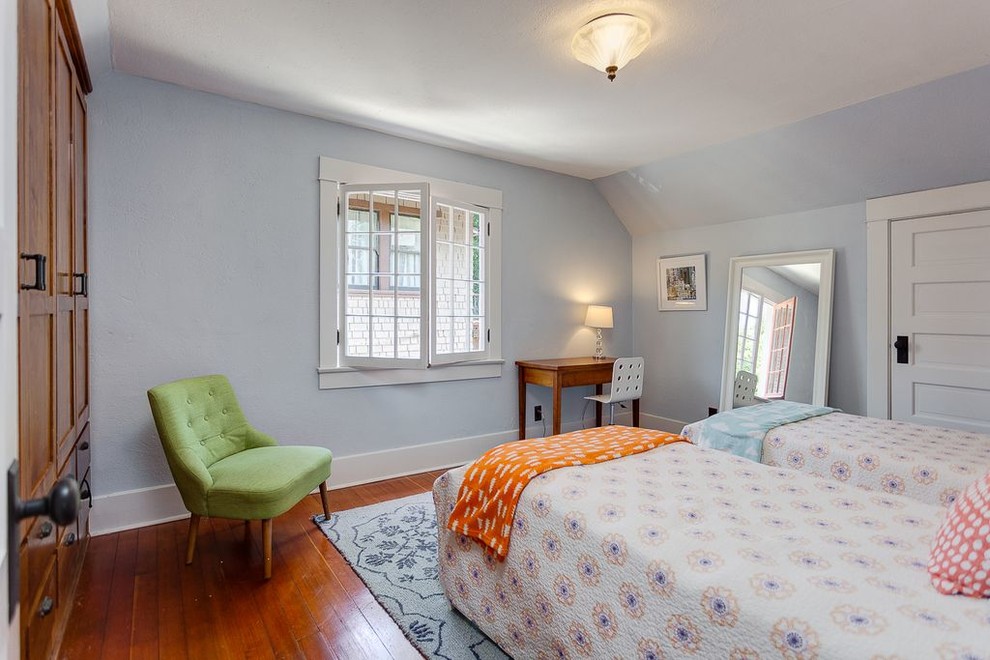 Imagen de habitación de invitados clásica de tamaño medio sin chimenea con paredes azules, suelo de madera en tonos medios y suelo marrón