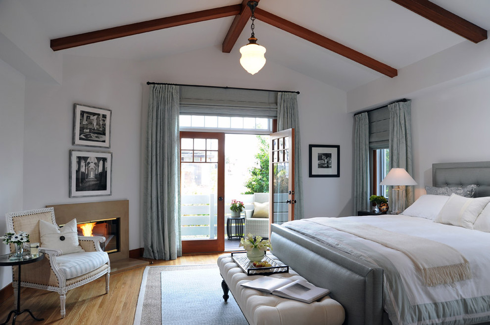 Exempel på ett klassiskt sovrum, med vita väggar, mellanmörkt trägolv och en öppen hörnspis