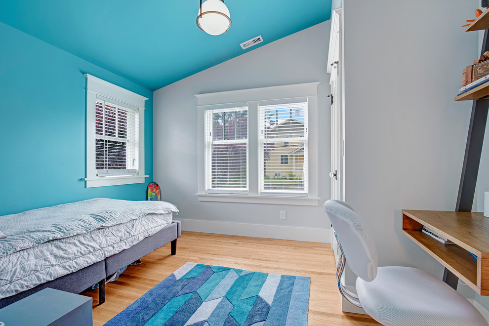 Ispirazione per una piccola camera da letto american style con pareti blu, parquet chiaro e pavimento marrone