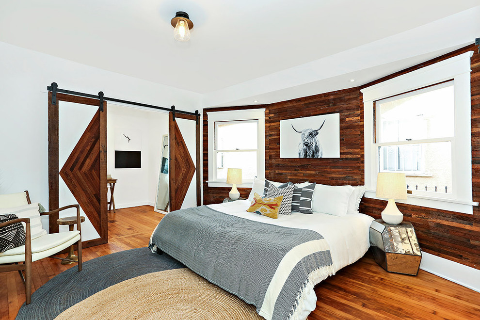 Idéer för amerikanska sovrum, med vita väggar, mellanmörkt trägolv och brunt golv
