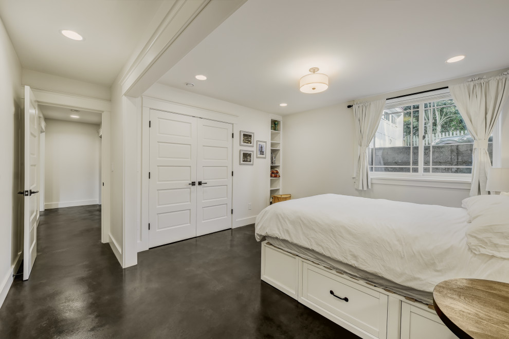 Modelo de habitación de invitados de estilo americano de tamaño medio con paredes blancas, suelo de cemento y suelo marrón